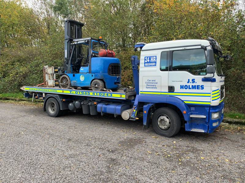 J.S. Holmes recovery truck transporting a forklift on its trailer